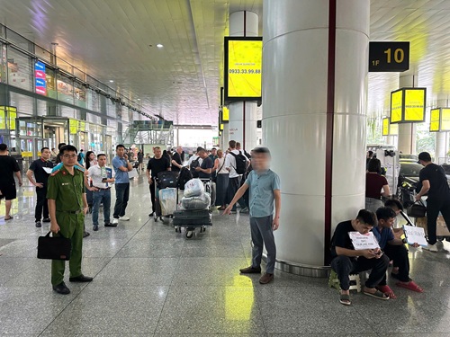 A driver holding a name sign in an airport arrivals hall