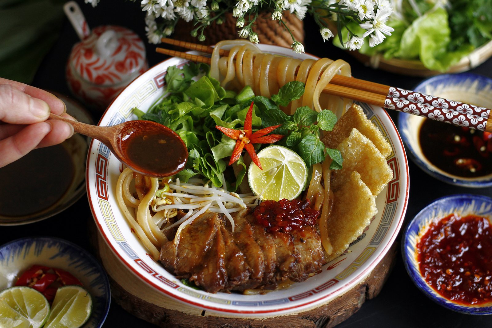 A bowl of cao lau noodles with pork, herbs and crispy croutons in Hoi An