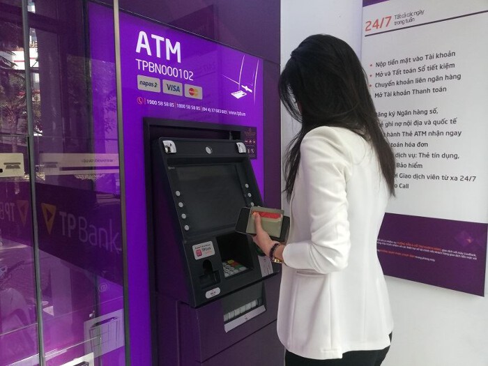 A traveller withdrawing Vietnamese dong from an ATM