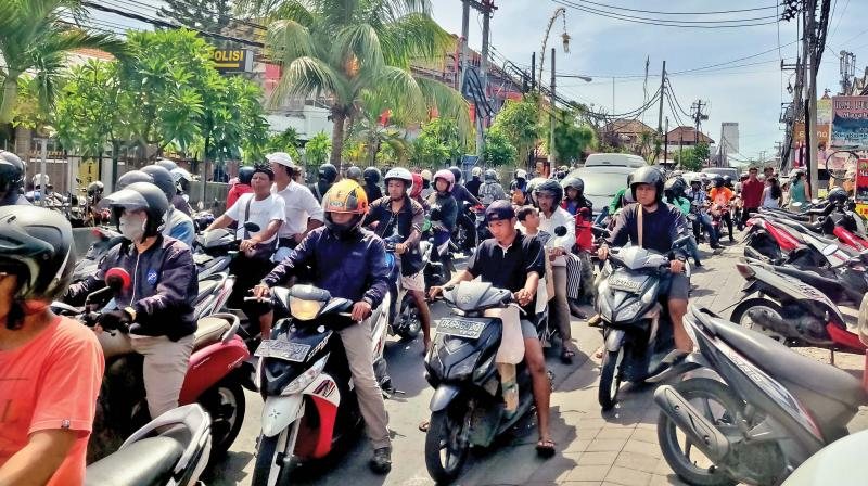 Scooters and cars in a traffic jam on a narrow road in Canggu, Bali