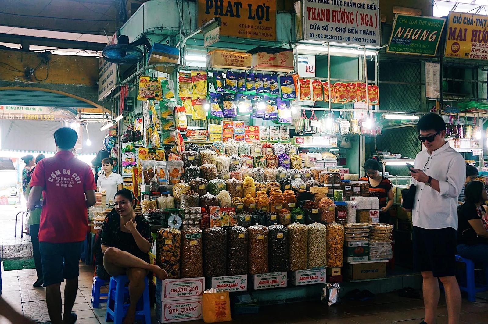 A stall in Ben Thanh Market piled high with jars and bags of dried fruit, nuts and sweets