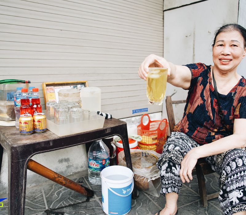 Bottled water and glasses of iced tea on a small table at a street café in Vietnam