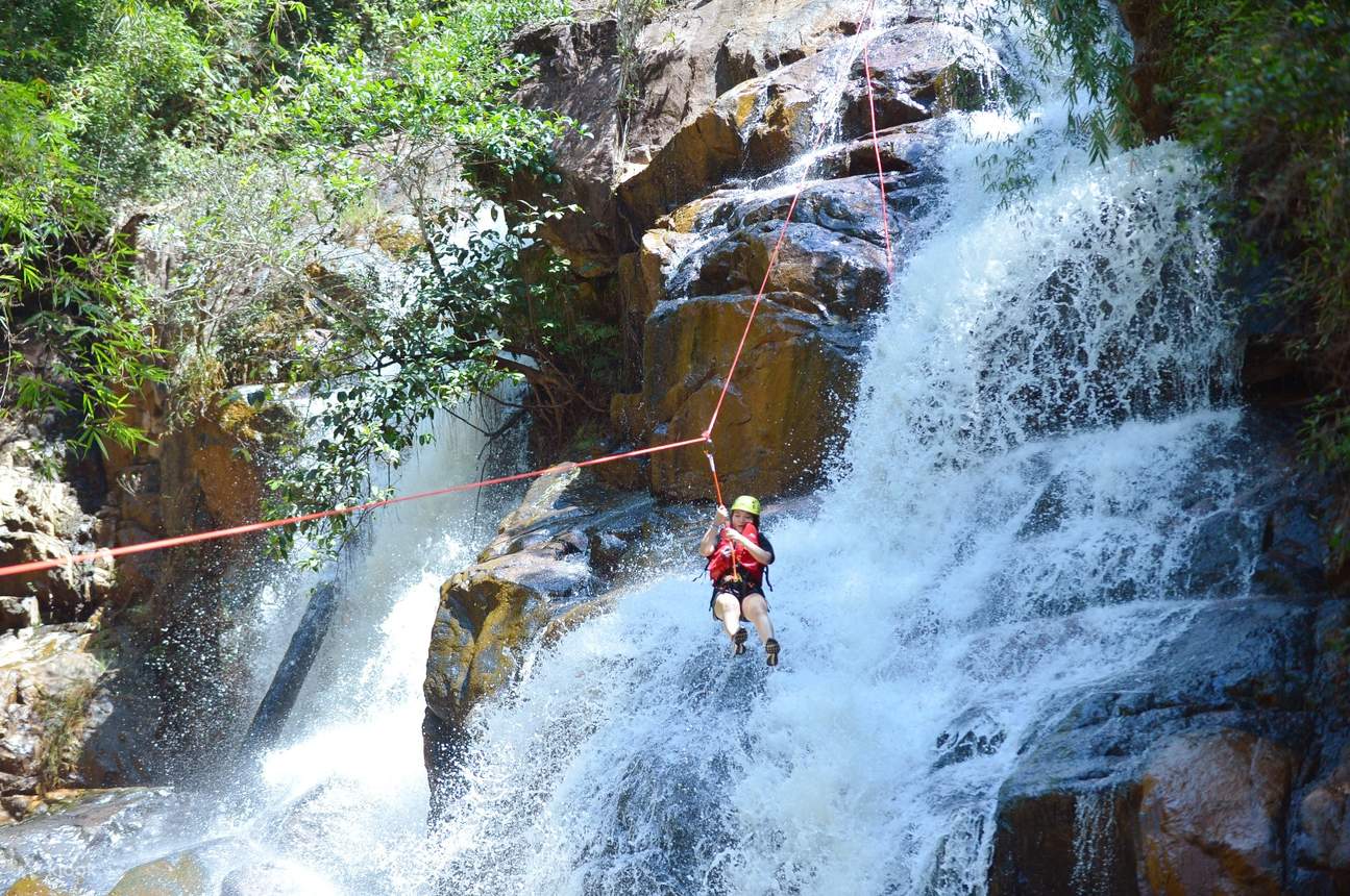A traveller abseiling down a waterfall on a canyoning tour in Da Lat