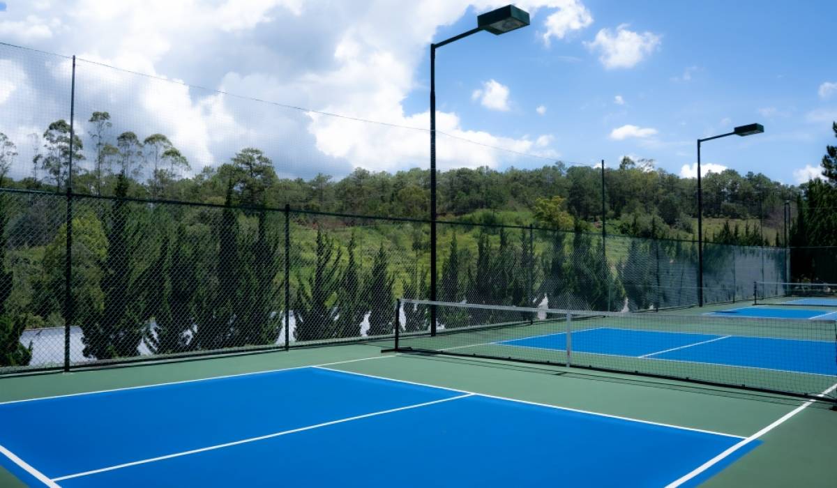 A pickleball court in Da Lat with pine-covered hills nearby