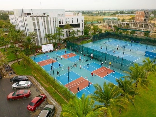Players on an outdoor pickleball court in Da Nang at sunrise in March