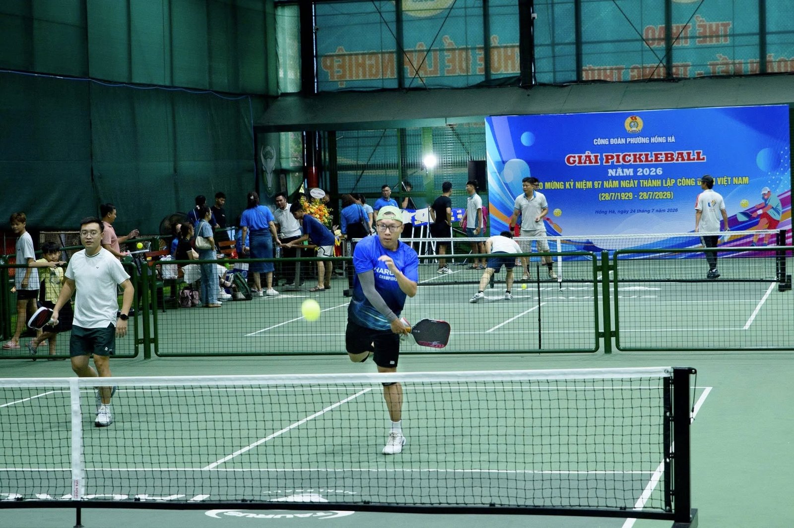 Visitors and local players at an evening pickleball drop-in session in Vietnam