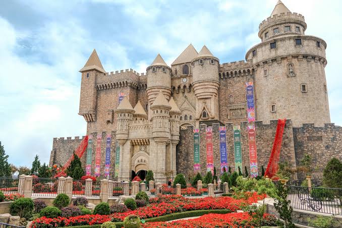 A fairytale-style castle with towers set among clouds on a mountain
