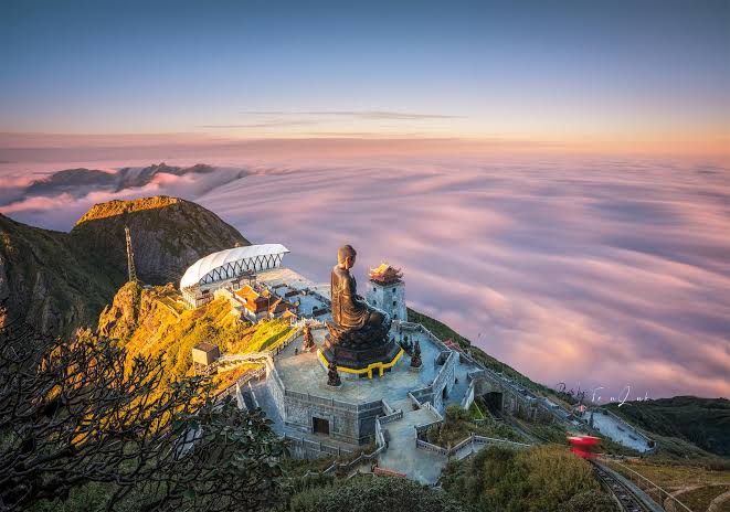 A giant bronze Buddha statue standing in the clouds on Fansipan mountain