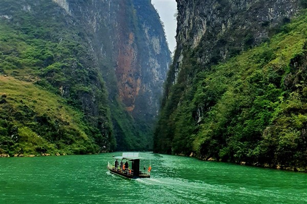 A small boat crossing the Nho Que River through the gorge below Ma Pi Leng Pass