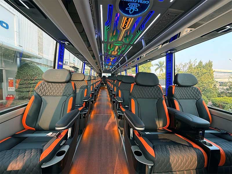 Inside a limousine bus with rows of reclining black and orange leather seats, the kind used between Hanoi and Ha Long