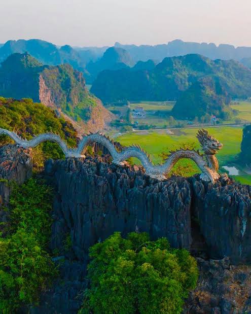 The stone dragon along the summit ridge of Hang Mua, above the karsts and rice fields of Tam Coc