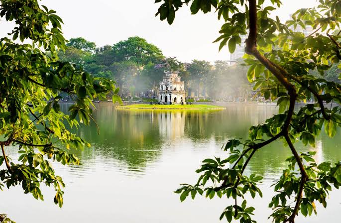 Hoan Kiem Lake in Hanoi on a clear autumn morning, with trees around the water