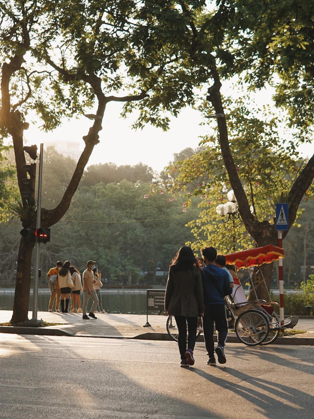 People in coats and scarves on a Hanoi street on a cool, misty December day