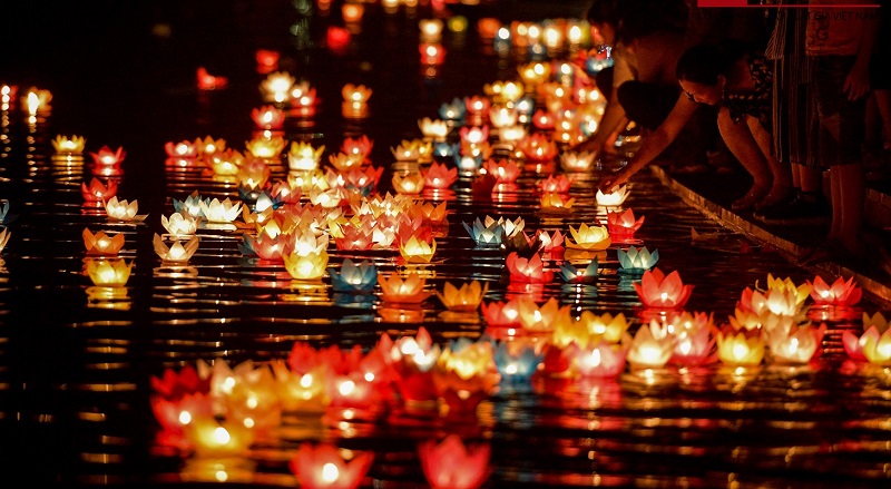 Red Tet lanterns and spring decorations over a street in Hoi An's old town