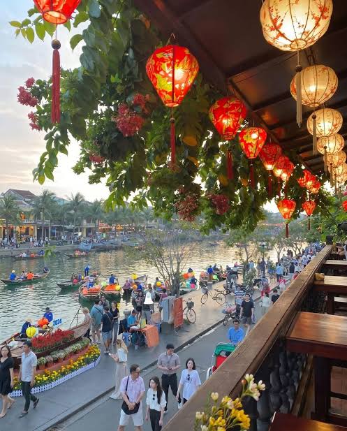 Relaxed travellers walking along the river in Hoi An in the evening