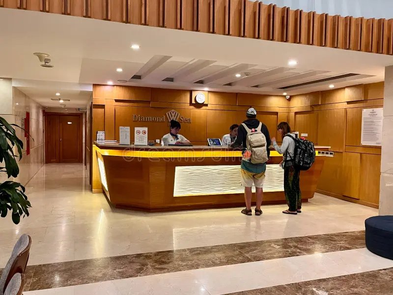 A hotel front desk with a receptionist welcoming guests in Vietnam