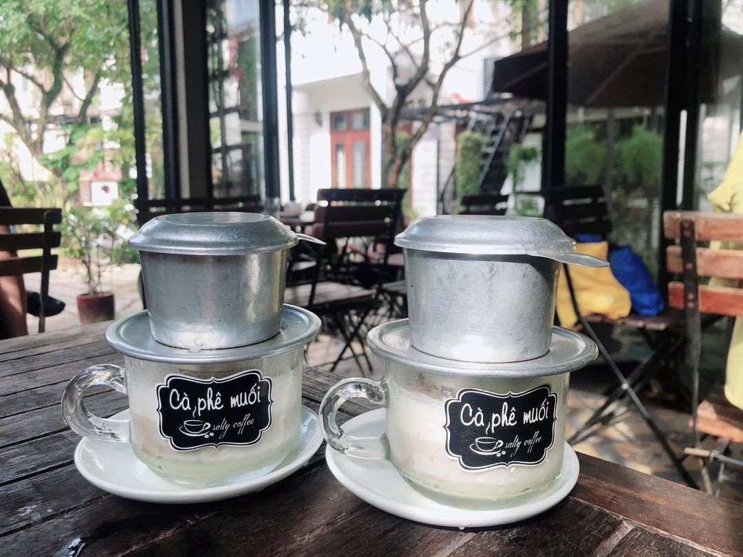 A glass of Hue salt coffee with salty cream on a café table