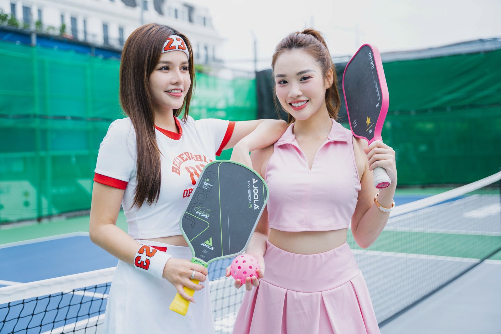 A light-coloured moisture-wicking pickleball shirt hanging to dry by a court in Vietnam