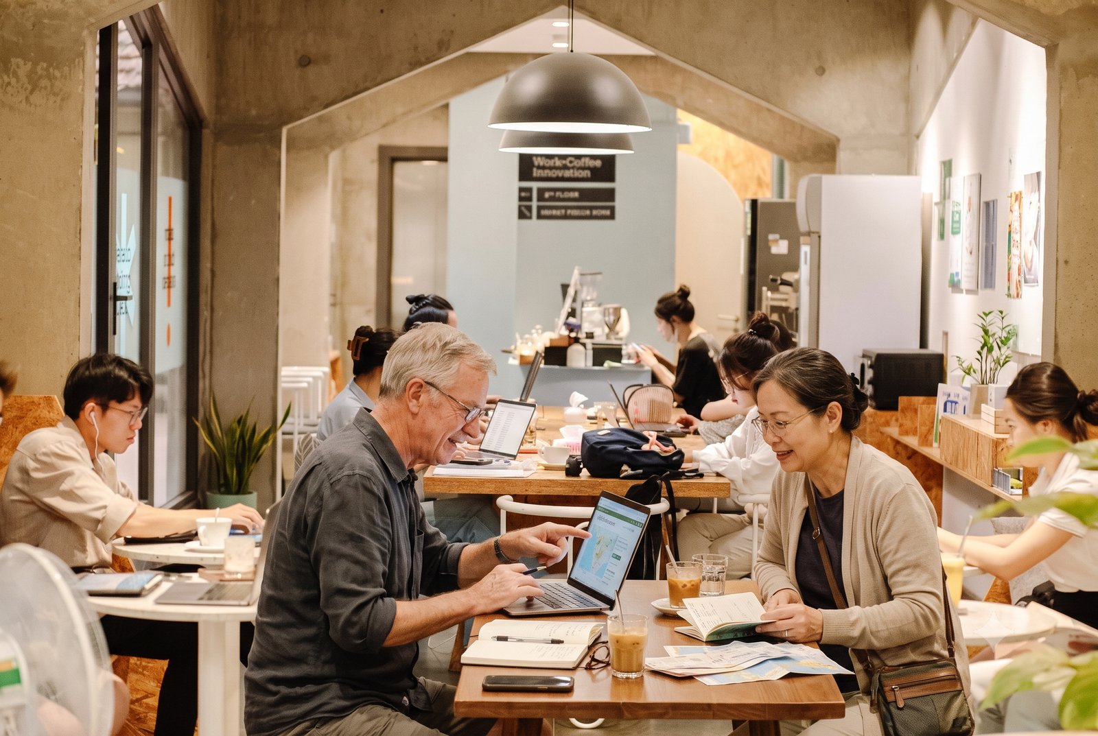 An older couple at a café table planning their retirement on a laptop