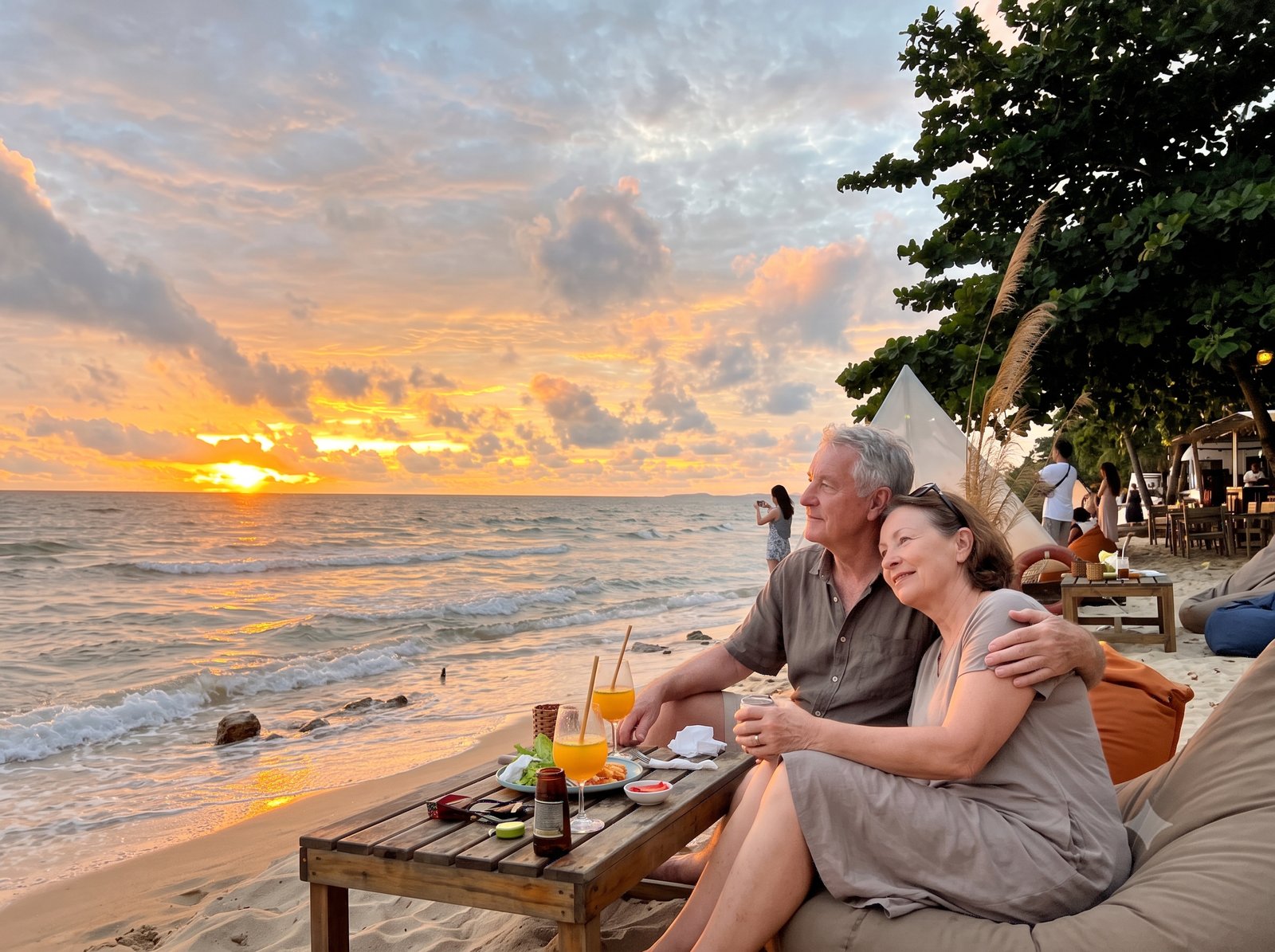 An older couple watching the sunset on a beach in Vietnam