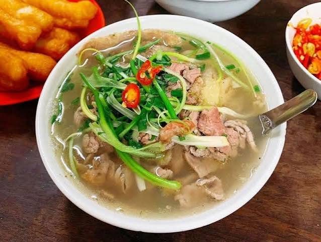 A steaming bowl of Hanoi pho with beef and herbs