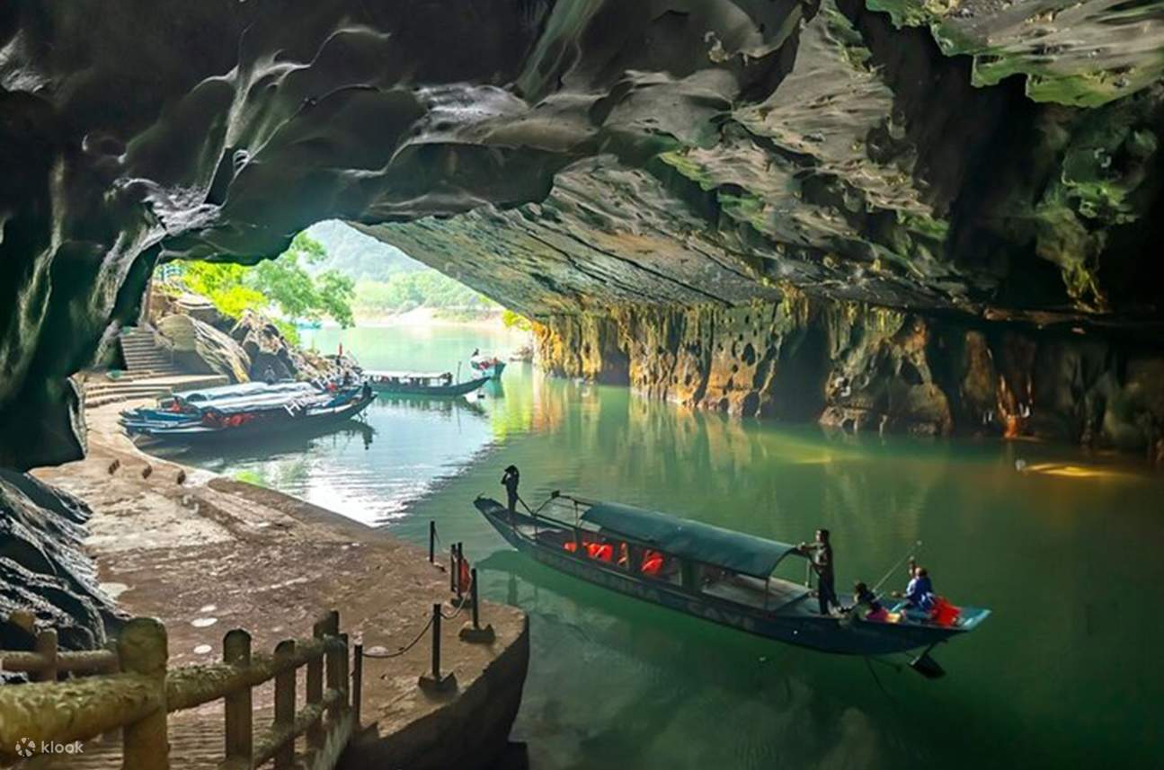 A wooden boat entering Phong Nha Cave from the river