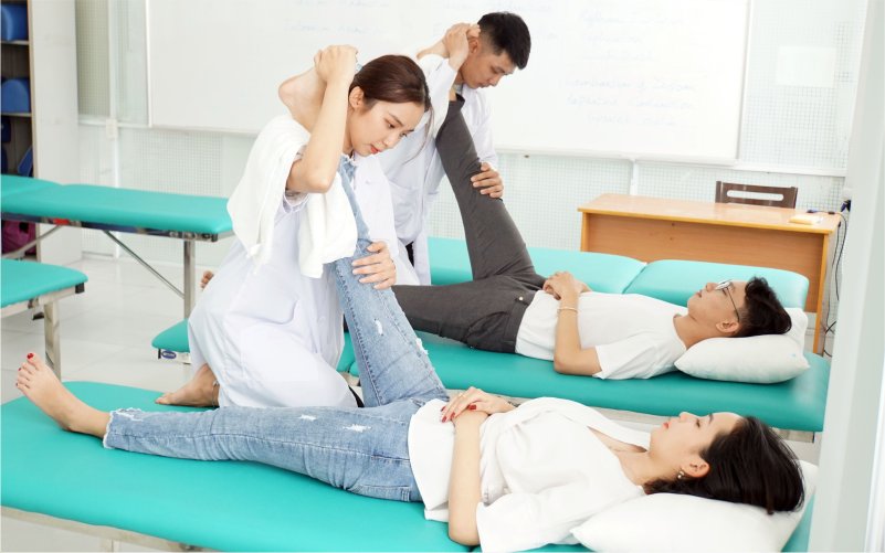 A physiotherapist treating a knee injury at a clinic in Vietnam