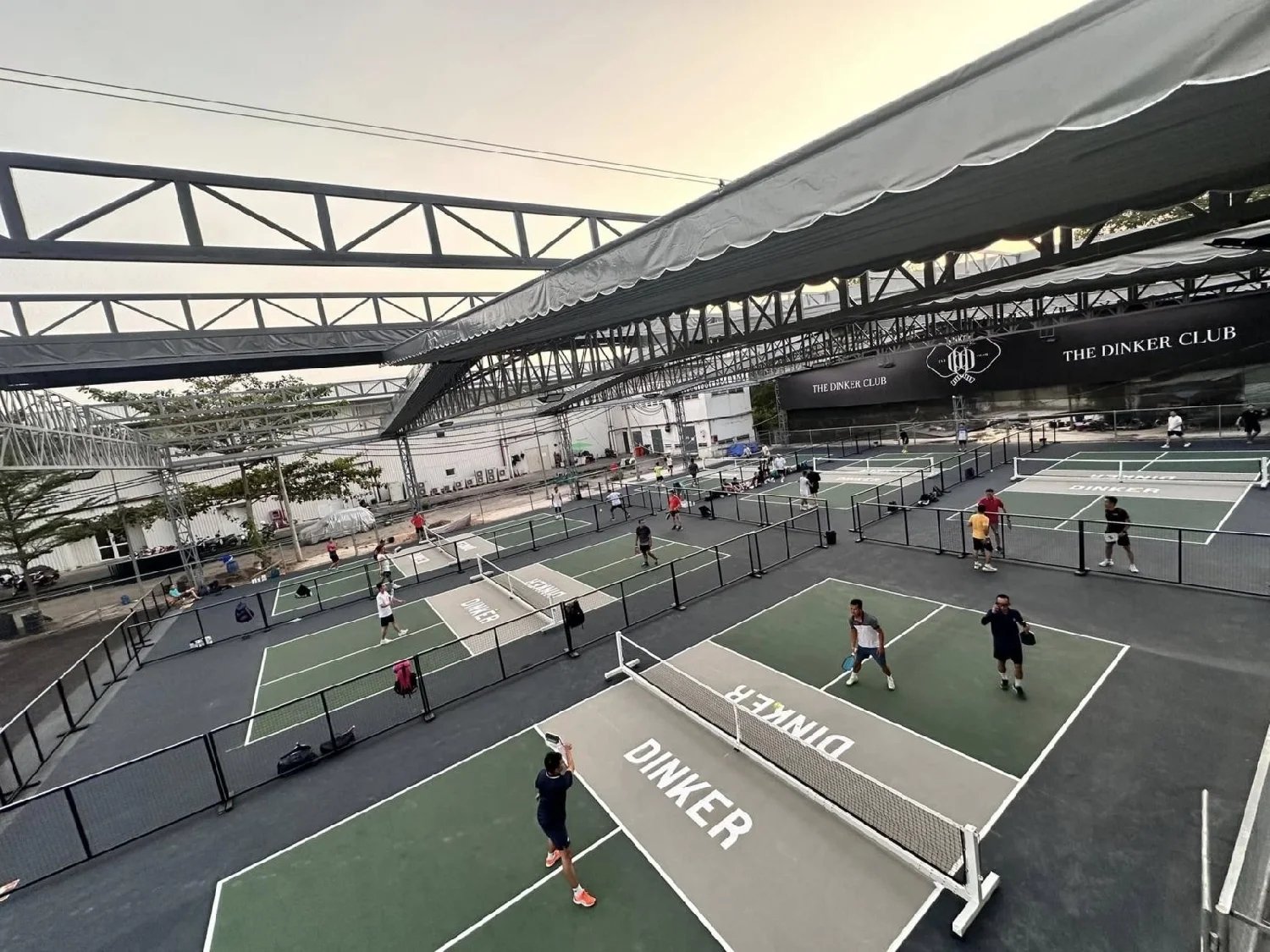 Players on sunny outdoor pickleball courts in Vietnam