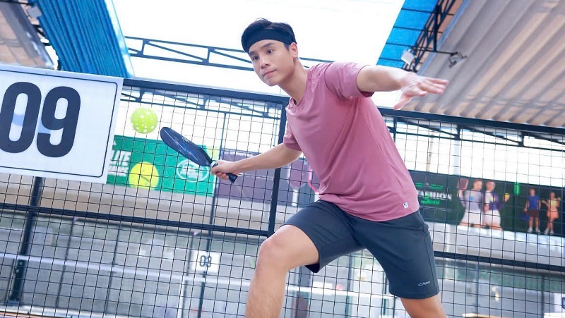 A player in a lightweight skort and a partner in athletic shorts on a pickleball court in Vietnam