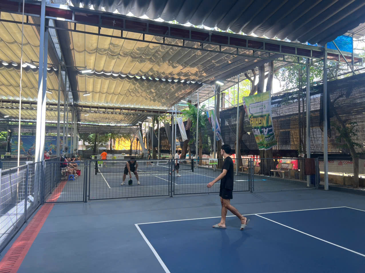Players on an outdoor pickleball court at sunrise during a pickleball vacation in Vietnam