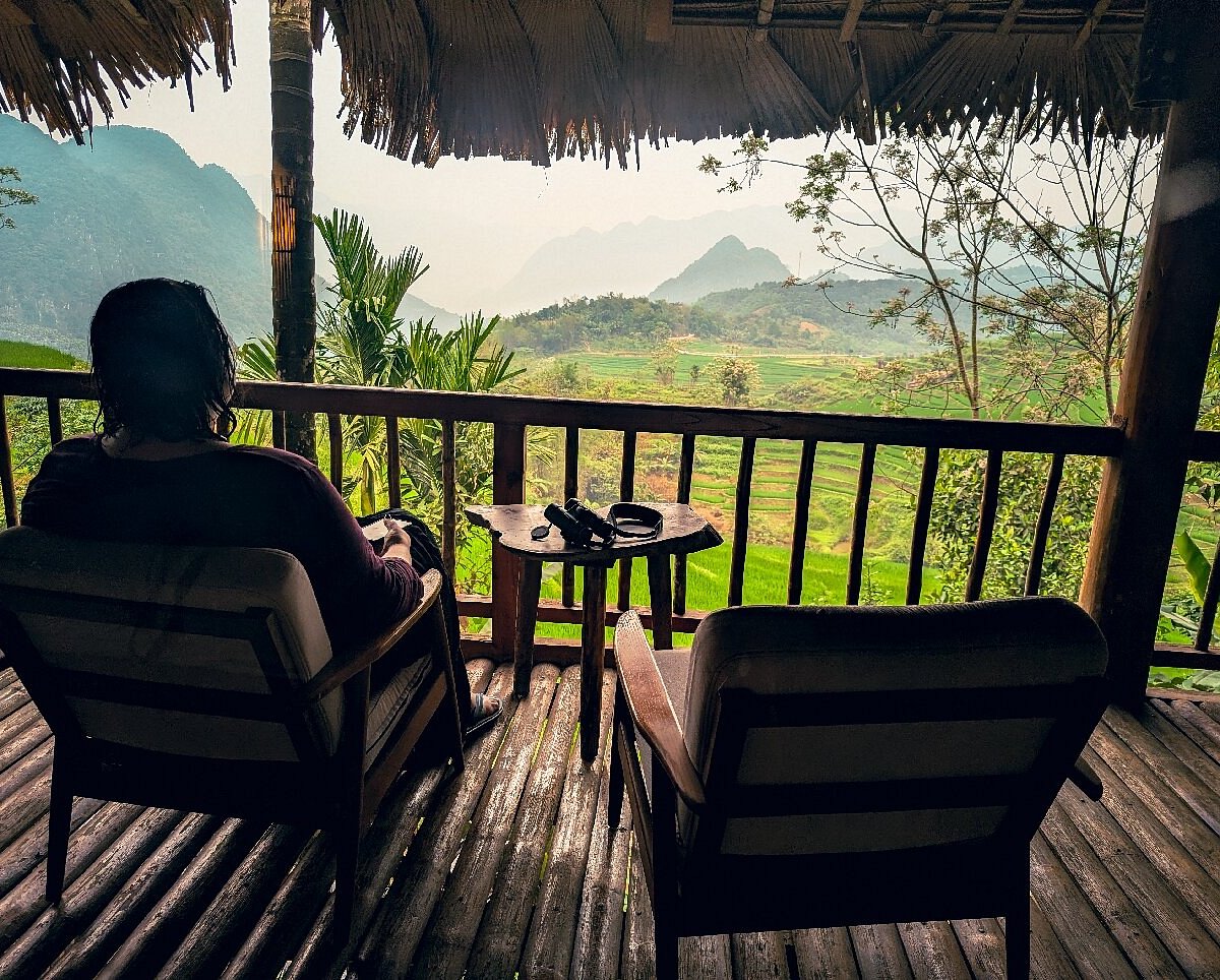 A wooden stilt house looking over the green valleys of Pu Luong