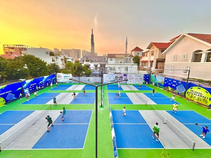Outdoor courts at RUDAL Pickleball Center in Ho Chi Minh City at sunset, with the city skyline in the background