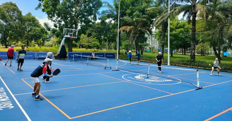 An outdoor pickleball game on a sunny, dry December morning in Ho Chi Minh City