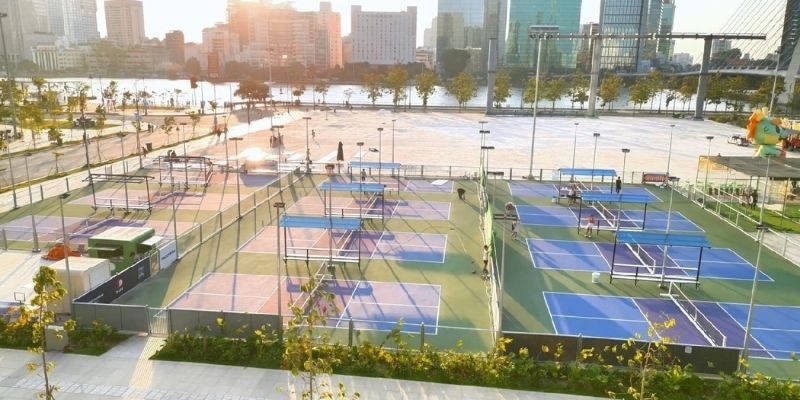 Riverside pickleball courts with the Ho Chi Minh City skyline behind, southern Vietnam
