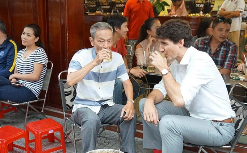 Locals drinking iced coffee on small plastic stools on a Saigon pavement