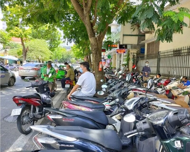 A row of rental scooters parked along a street in Vietnam