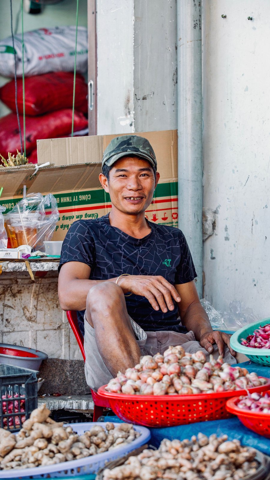 A smiling vendor at a market stall in Vietnam