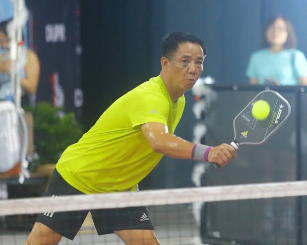 A solo traveller over 50 joining a doubles game with local players in Vietnam