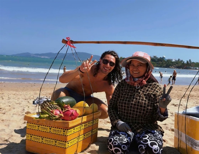 A traveller chatting and laughing with a local street vendor in Vietnam