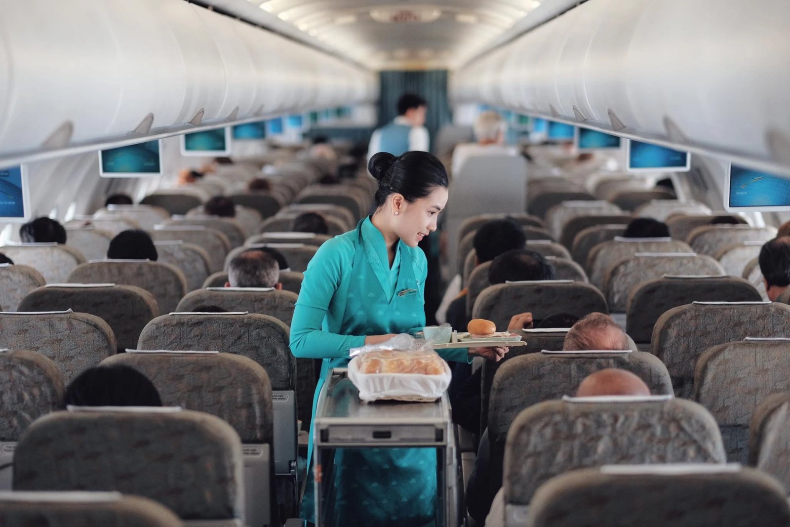 A Vietnam Airlines flight attendant serving passengers on a domestic flight