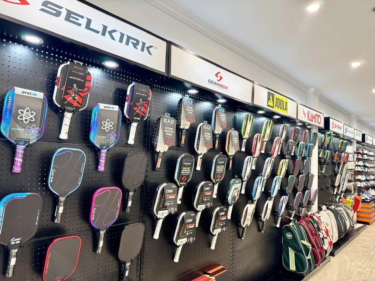 A wall of pickleball paddles from Vietnamese and international brands in a sports shop in Vietnam