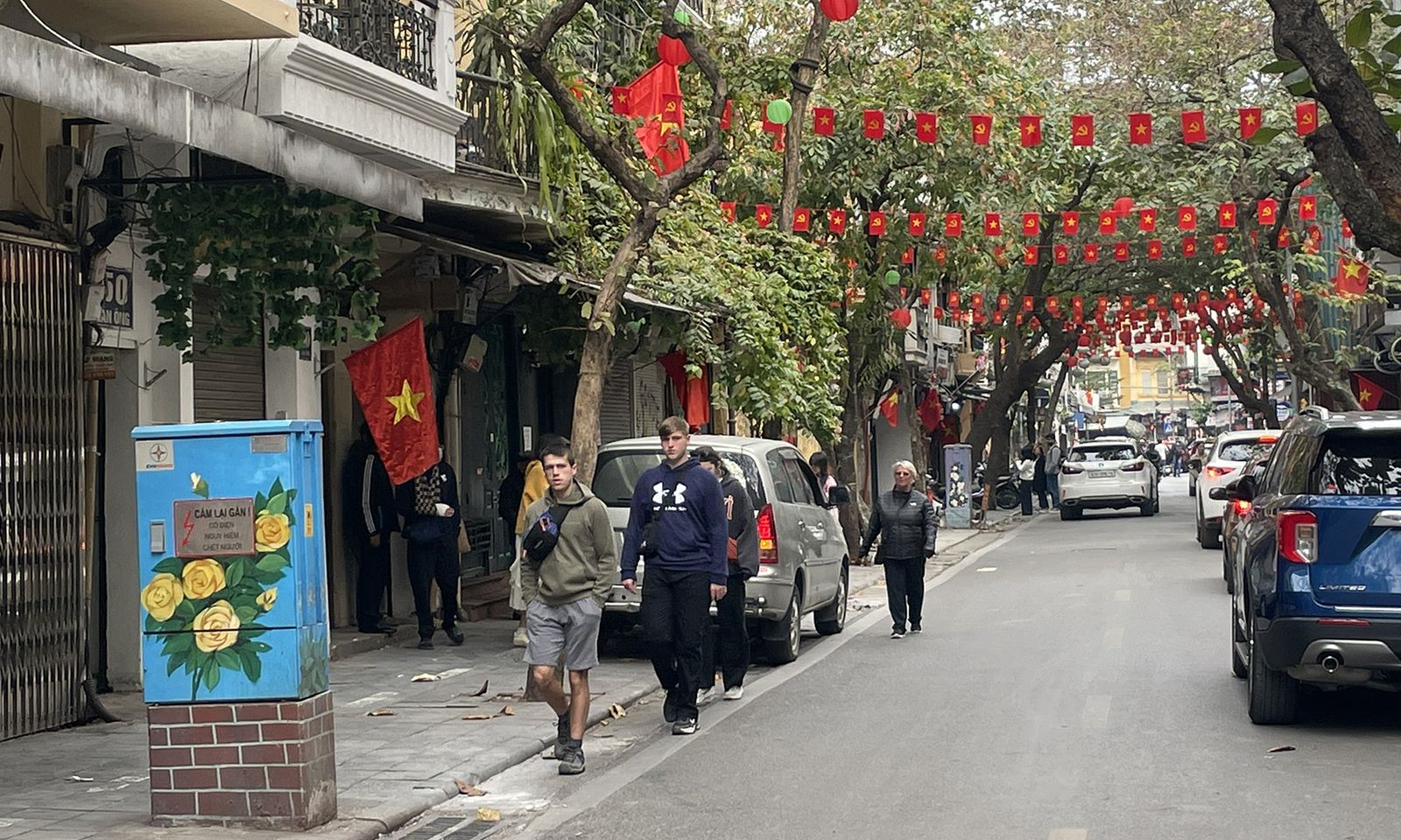 A row of shops with their shutters down and red Tet decorations on a quiet street in Vietnam