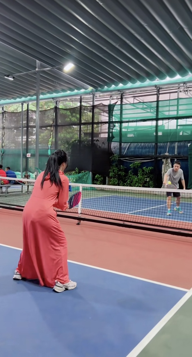 Vietnamese pickleball players wearing sun sleeves, caps and face covers on an outdoor court