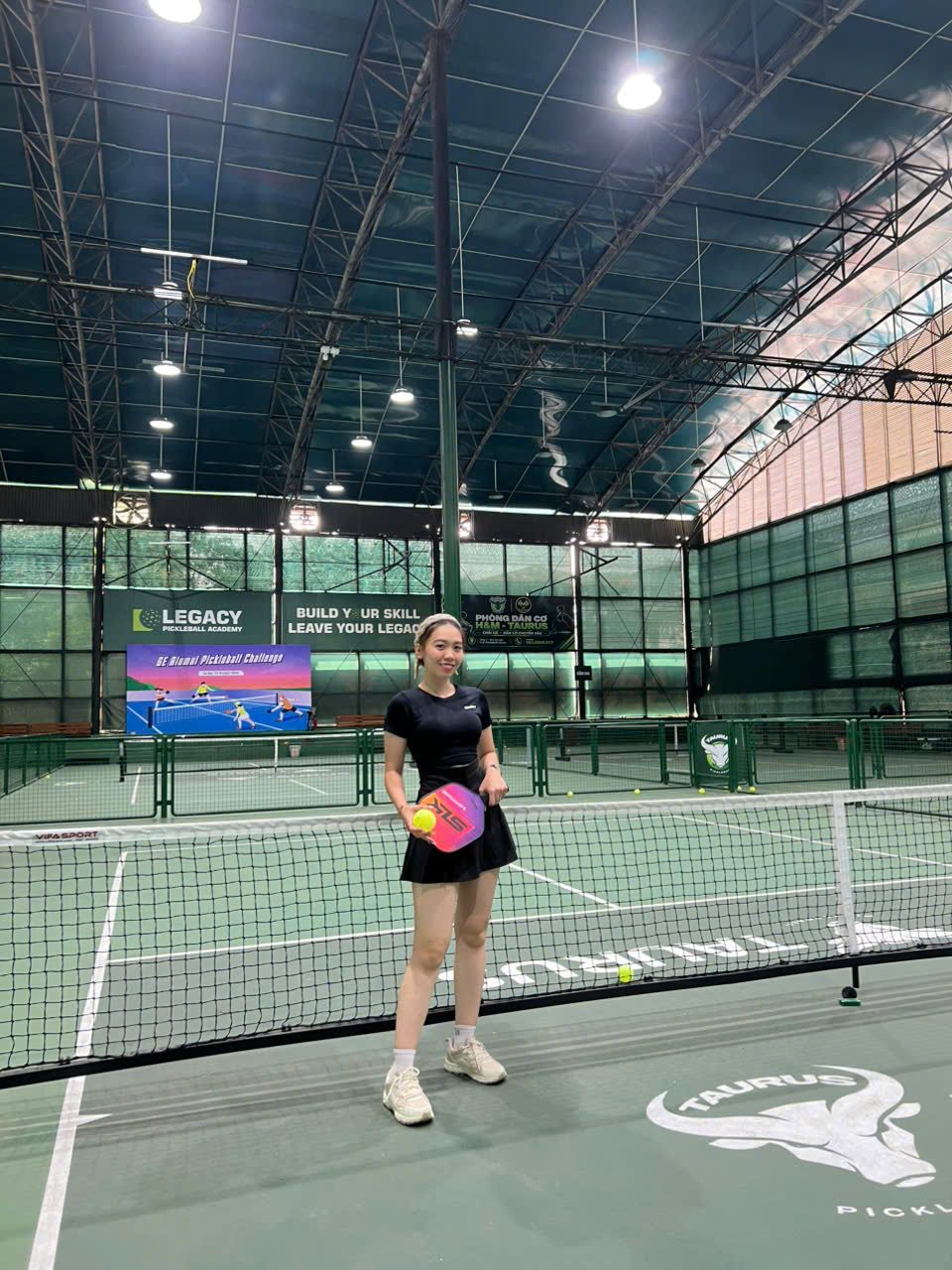 Jenny, one of our tour guides, by the net with a paddle at Taurus, Hanoi