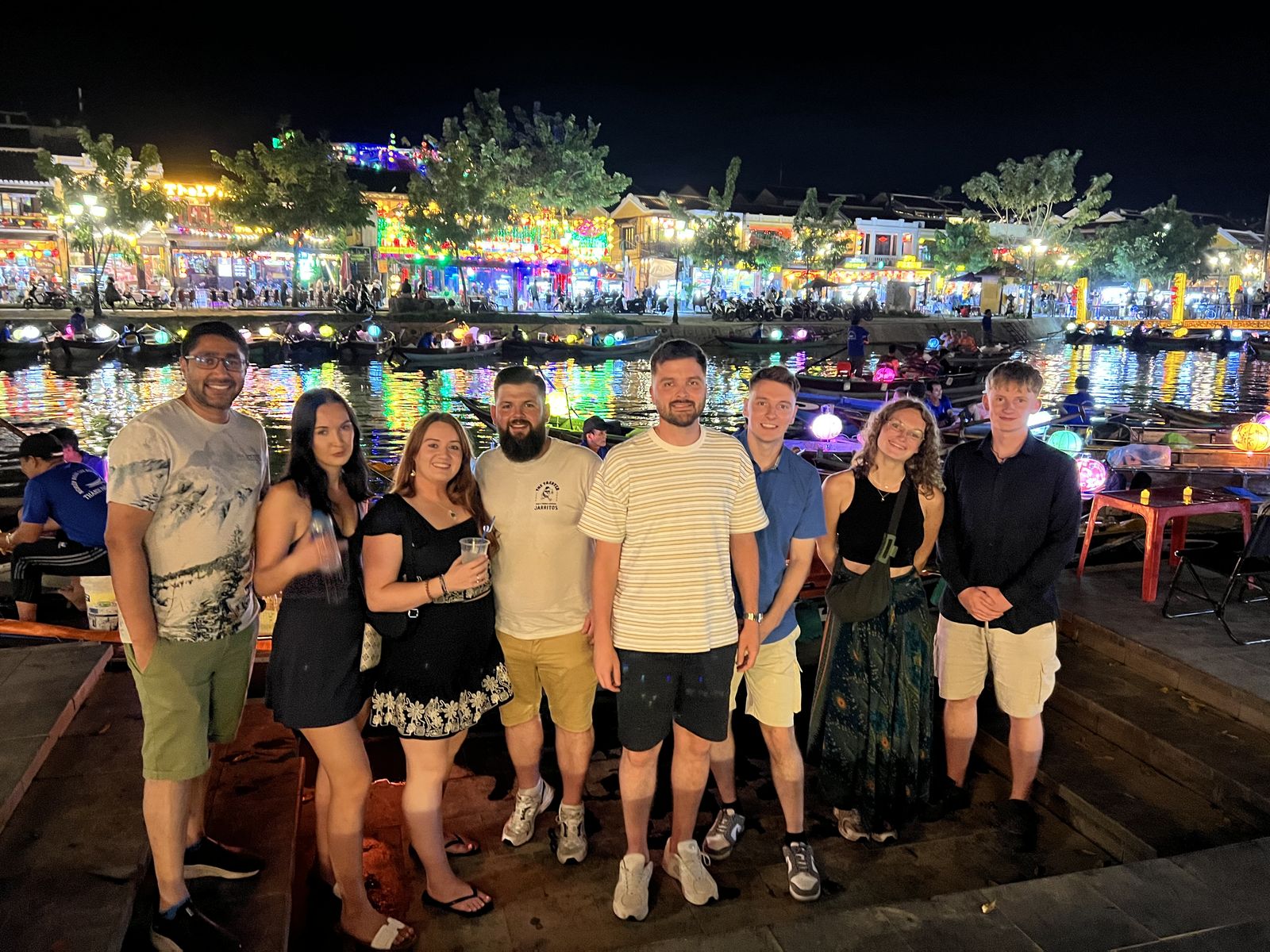 Our guests by the river in Hoi An at night, with the lanterns behind them
